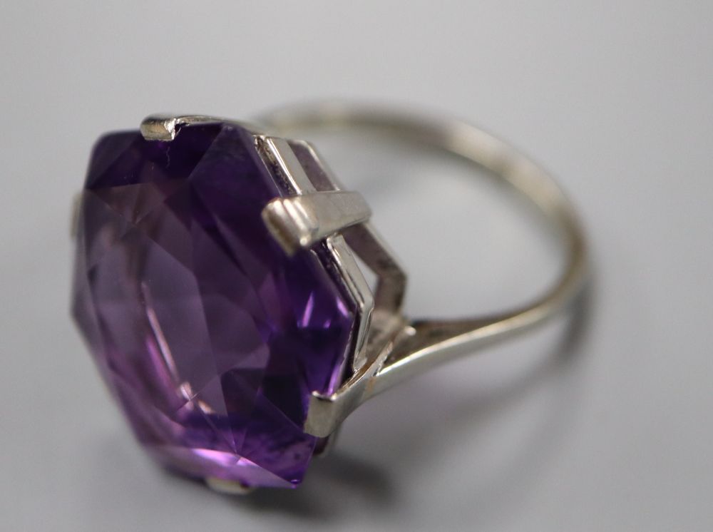 A white metal (stamped 18ct) and fancy hexagonal cut solitaire amethyst dress ring, size K, gross 6.3 grams.